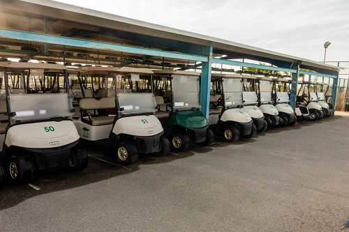 Torrevieja, Valenciana, Spain - May 04 2020 : row of golf buggies on golf course in spain, idle due to covid-19 lock down