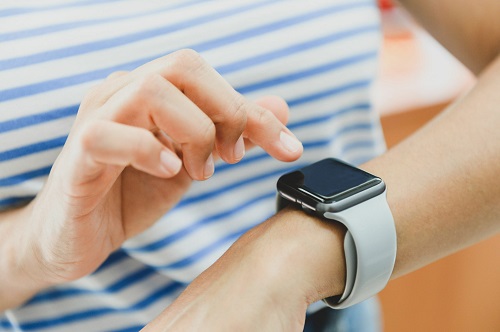 woman and man hand using apple smart watch. woman is touching the screen of her apple smart watch. women who actively use technology in everyday life